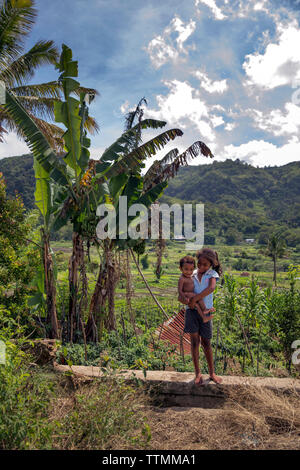 INDONESIA, Flores, una giovane ragazza trattiene il suo fratellino in villaggio Waturaka Foto Stock