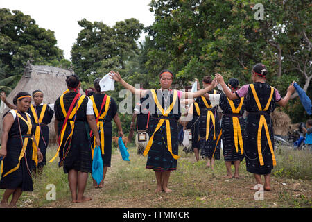 INDONESIA, Flores, Ngadha District, i residenti del villaggio Belaraghi ballare e cantare per dare il benvenuto agli ospiti nel loro villaggio Foto Stock