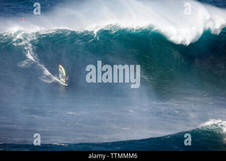 Stati Uniti d'America, Hawaii Maui, un uomo surf sulle onde enormi in corrispondenza di una interruzione chiamati ganasce o Peahi Foto Stock