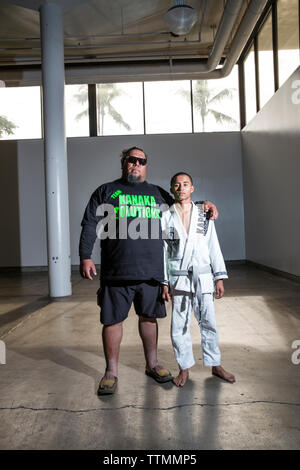 Stati Uniti d'America, Oahu, Hawaii, ritratto Kobe un giovane Jujitsu Arti Marziali fighter con suo padre Kimo prima dell'inizio dell'icona alle prese nel torneo di Honolu Foto Stock