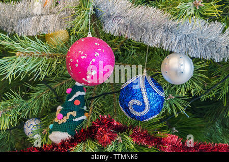 Frammento di splendidamente decorate tinsel, giocattoli e ghirlande di Natale di abete Foto Stock