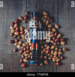 Vista aerea del schiaccianoci in legno e figurine di alimenti secchi sul tavolo Foto Stock