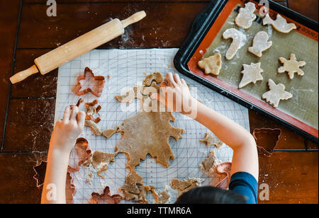 Colpo di overhead del bambino le mani rendendo i cookie utilizzando cookie cutter. Foto Stock