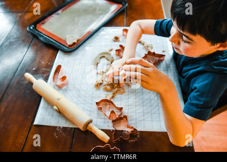 Colpo di overhead del bambino sta facendo i cookie con cookie cutter. Foto Stock