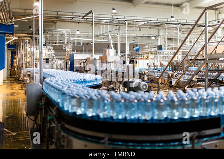 Bottiglie di acqua sul nastro trasportatore nell'industria Foto Stock