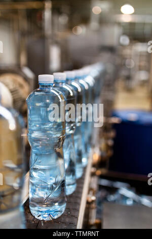 Close-up di bottiglie di acqua in fila in fabbrica Foto Stock