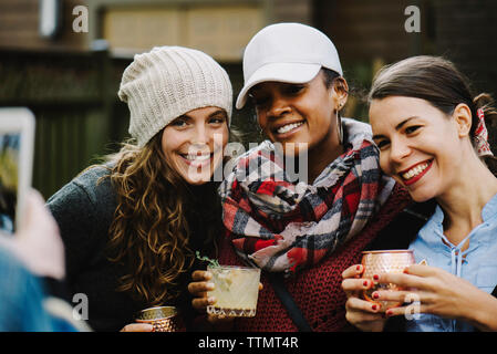 Gli amici sorseggiando un drink nel cortile posteriore Foto Stock