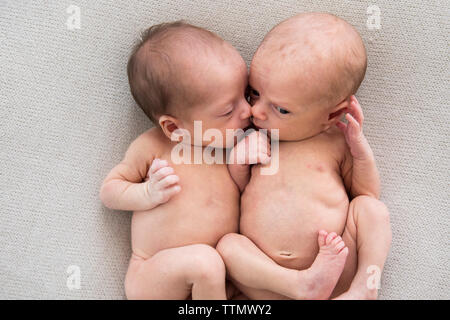 Twin neonato ragazze che stabilisce insieme su Off-White coperta Foto Stock
