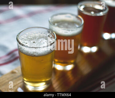 Angolo di Alta Vista della birra in bicchieri da igienico sul tavolo di legno Foto Stock