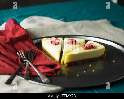 Fette di cheesecake con igienico e le forche nella piastra sulla tavola Foto Stock