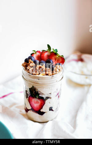 Frutti di bosco freschi con yogurt in vaso sul tavolo Foto Stock