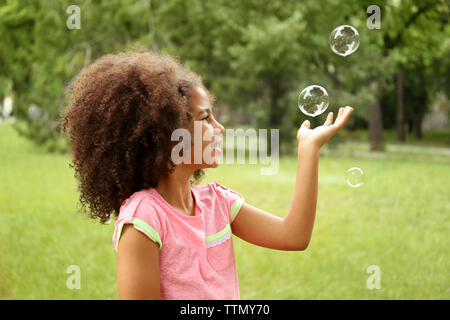 Afro-americani bambina cattura bolle di sapone Foto Stock