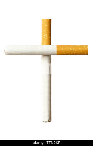 In prossimità di due sigarette formanti una tomba croce su sfondo bianco Foto Stock