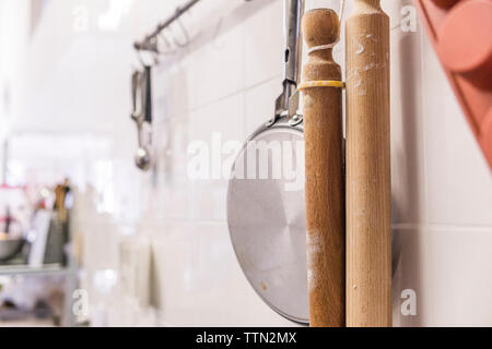 Close-up di perni di rotolamento con brasiera appeso alla parete in cucina in laboratorio Foto Stock