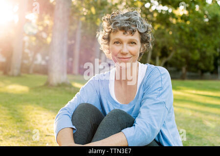 Ritratto di donna matura seduta sul campo Foto Stock