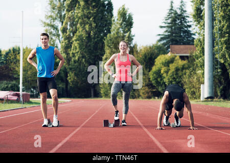 Guide di scorrimento in piedi in blocchi di partenza sulla via Foto Stock