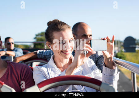 Donna fotografare durante il viaggio in autobus a due piani Foto Stock