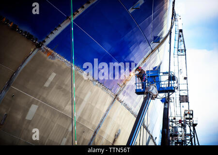 Basso angolo vista del lavoratore la saldatura nave presso l'industria Foto Stock