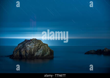 Le formazioni rocciose in mezzo al mare al Bandon Beach contro star sentieri Foto Stock