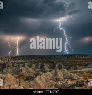 Angolo di alta vista maestosa delle formazioni rocciose a Parco nazionale Badlands contro la tempesta e fulmini Foto Stock