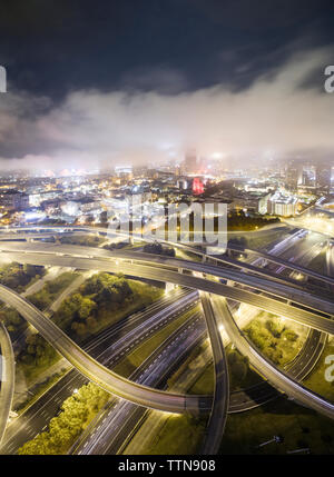 Vista aerea delle intersezioni stradali in città illuminata di notte Foto Stock