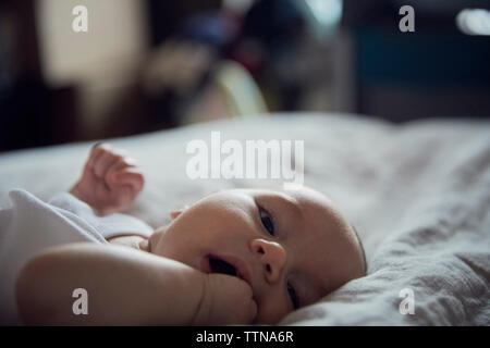 Ritratto di bimbo giacente sul letto di casa Foto Stock
