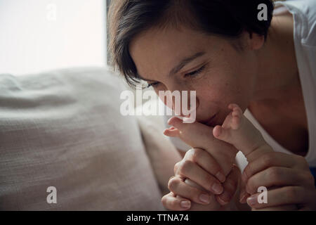 Madre figlio di baciare i piedi sul divano di casa Foto Stock