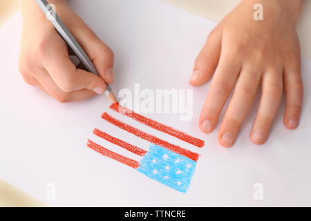 Bambino con le mani in mano Disegno bandiera americana sulla carta Foto Stock