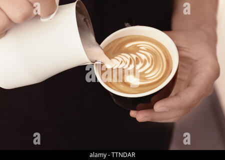 L'uomo disegno sul caffè con schiuma di latte Foto Stock