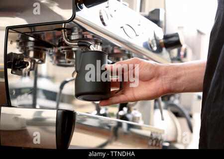 Barista latte di mantecazione in macchina da caffè Foto Stock