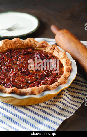 Vista ad angolo alto della torta di pecan nel recipiente sul tavolo a casa Foto Stock