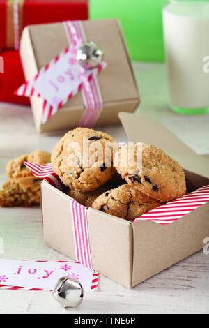 Vista ad angolo alto dei biscotti al cioccolato in scatola di cartone sul tavolo di legno a casa Foto Stock
