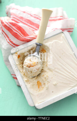 Vista ravvicinata dall'alto del gelato alla pesca fatto in casa con misurino da servire sul tavolo Foto Stock