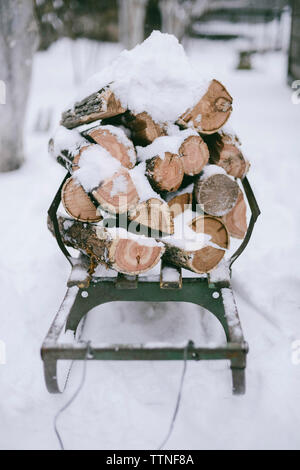 Pila di coperta di neve trito di legno sulla slitta Foto Stock