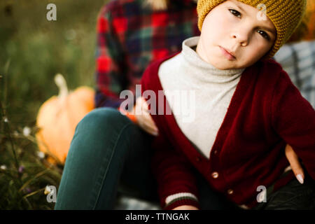 Ragazzo seduto con cappello giallo sul suo capo all'aperto. Foto Stock