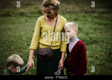 Due bambini che giocano con la loro madre su una bella giornata d'autunno Foto Stock