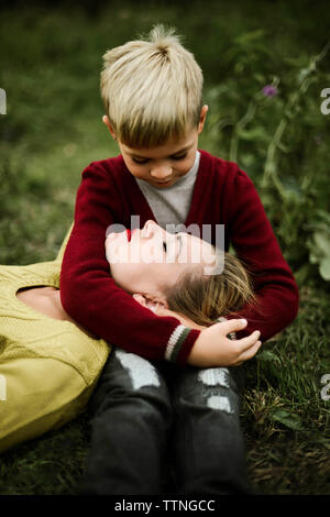 Figlio abbracciando la madre sul campo in campagna Foto Stock