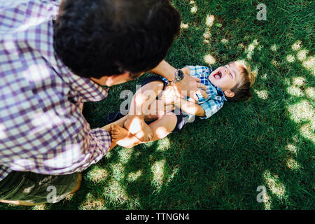 Elevato angolo di visione del padre giocando con il figlio sul campo erboso Foto Stock