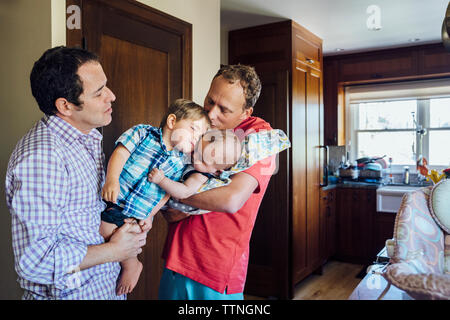 Coppia omosessuale holding figli a casa Foto Stock