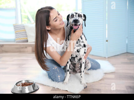 Proprietario femmina alimentando il suo cane dalmata Foto Stock