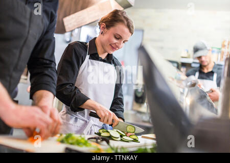 Chef tritare verdure al ristorante cucina Foto Stock