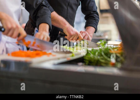 Sezione mediana di chef tritare verdure al ristorante cucina Foto Stock