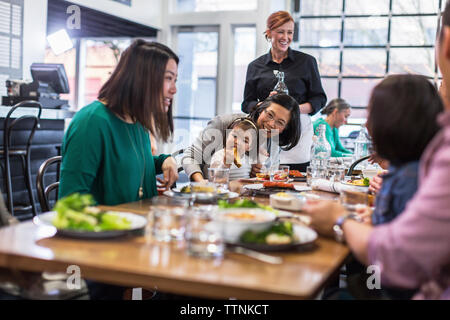 Cameriera di servire la famiglia al ristorante Foto Stock