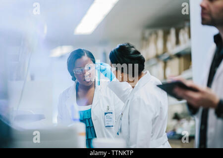 Medici di sesso femminile esaminando le provette per la prova in laboratorio Foto Stock