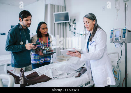 Medico donna formazione collaboratori su tablet computer nella scuola medica Foto Stock