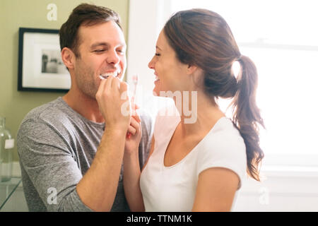 Coppia felice la spazzolatura dei denti nella stanza da bagno Foto Stock