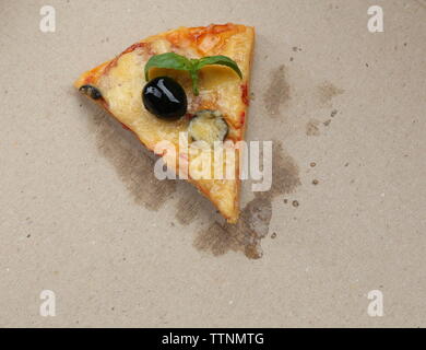 Gustoso trancio di pizza con olive su sfondo di cartone Foto Stock