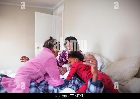 Famiglia allegra trascorrere il tempo libero in camera da letto Foto Stock