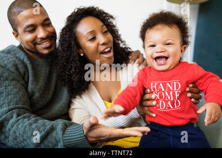 Allegro baby boy giocando con i genitori a casa Foto Stock