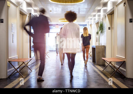 Vista posteriore del business la gente camminare in ufficio creativo lobby Foto Stock